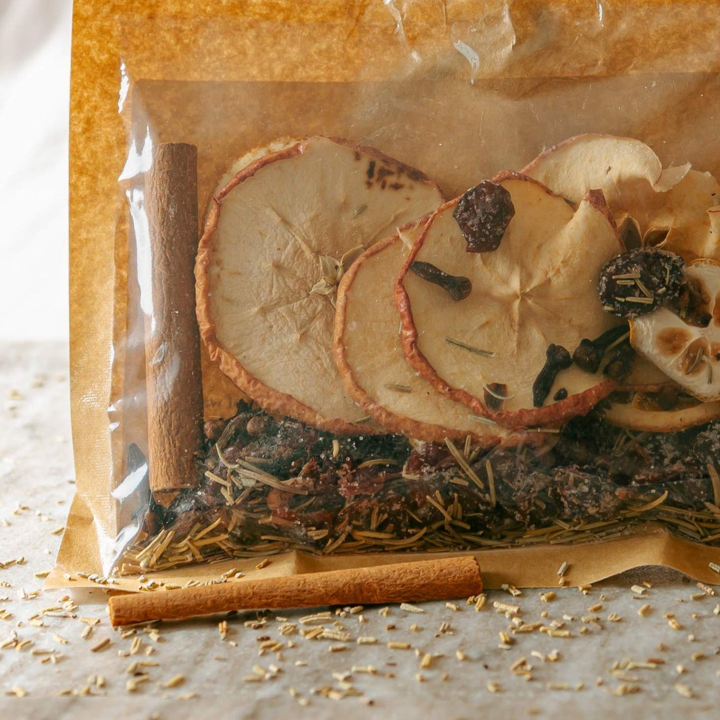 Packaged herbs with dried fruit and cinnamon on a wooden surface