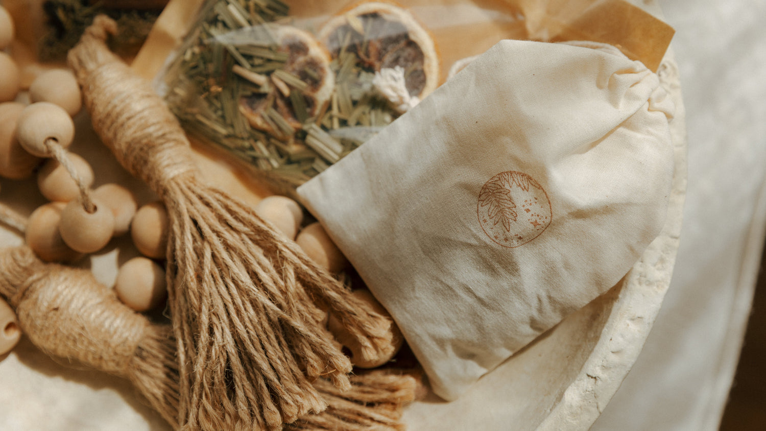 Herbal bag, tassel, and wooden beads on a textured surface