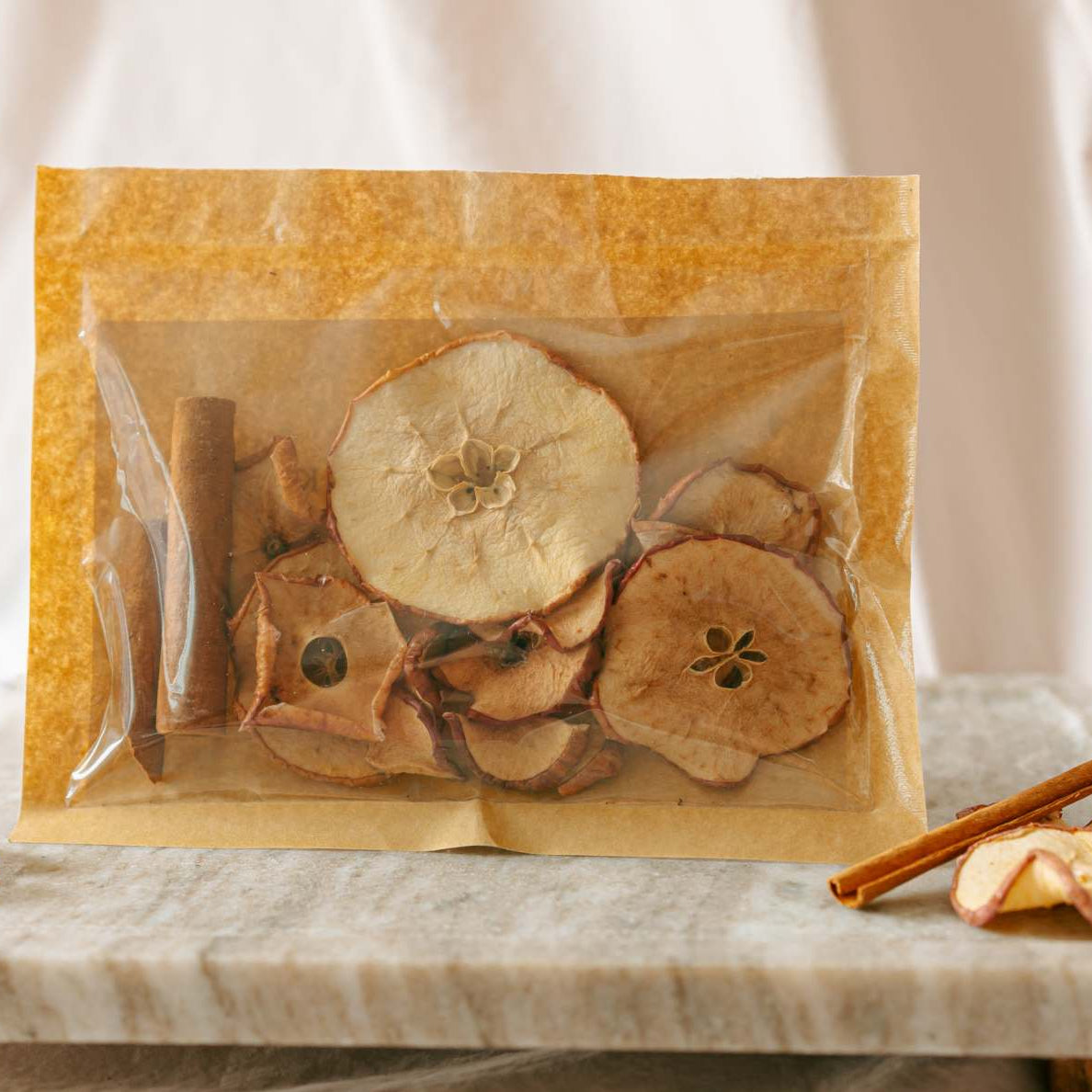 Bag of dried apples on a marble tray with a white background