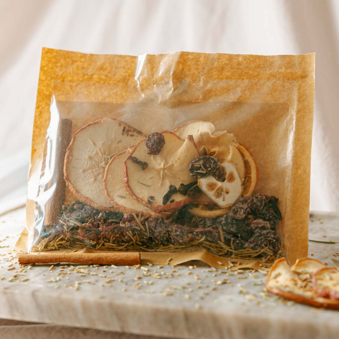 Packaged dried fruit mix on a marble slab with a white background