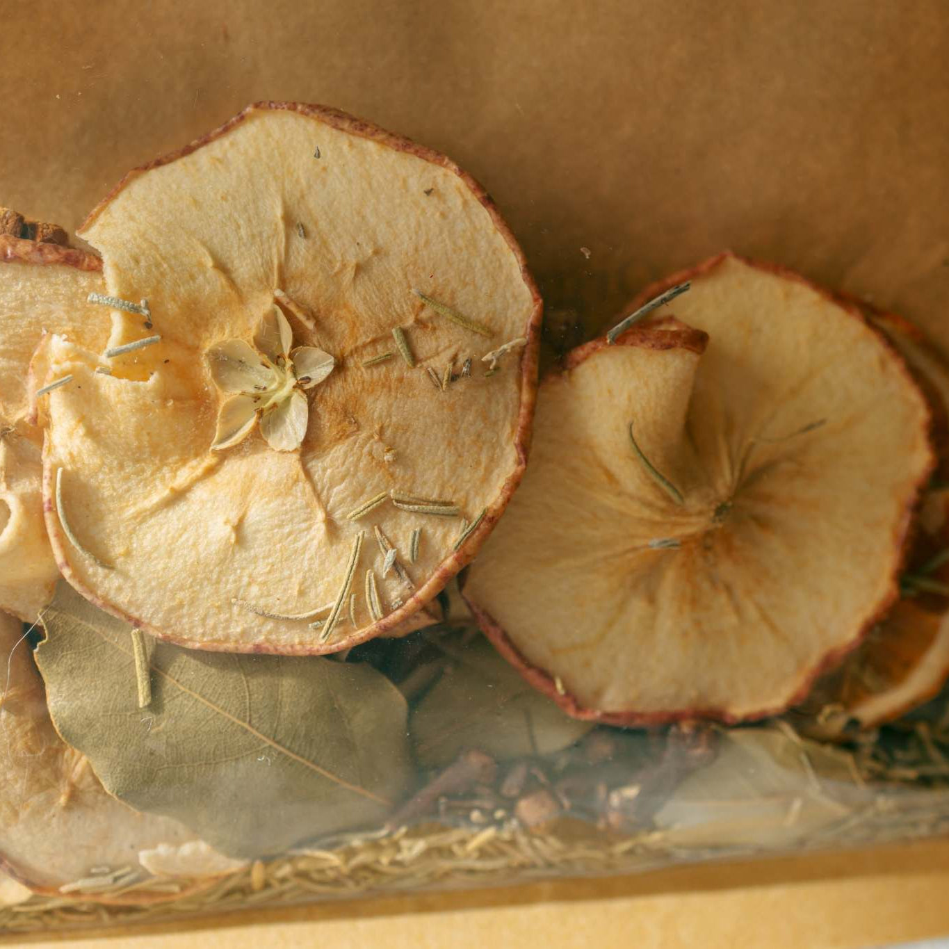 Dried fruits and herbs in a clear plastic bag with a brown paper background