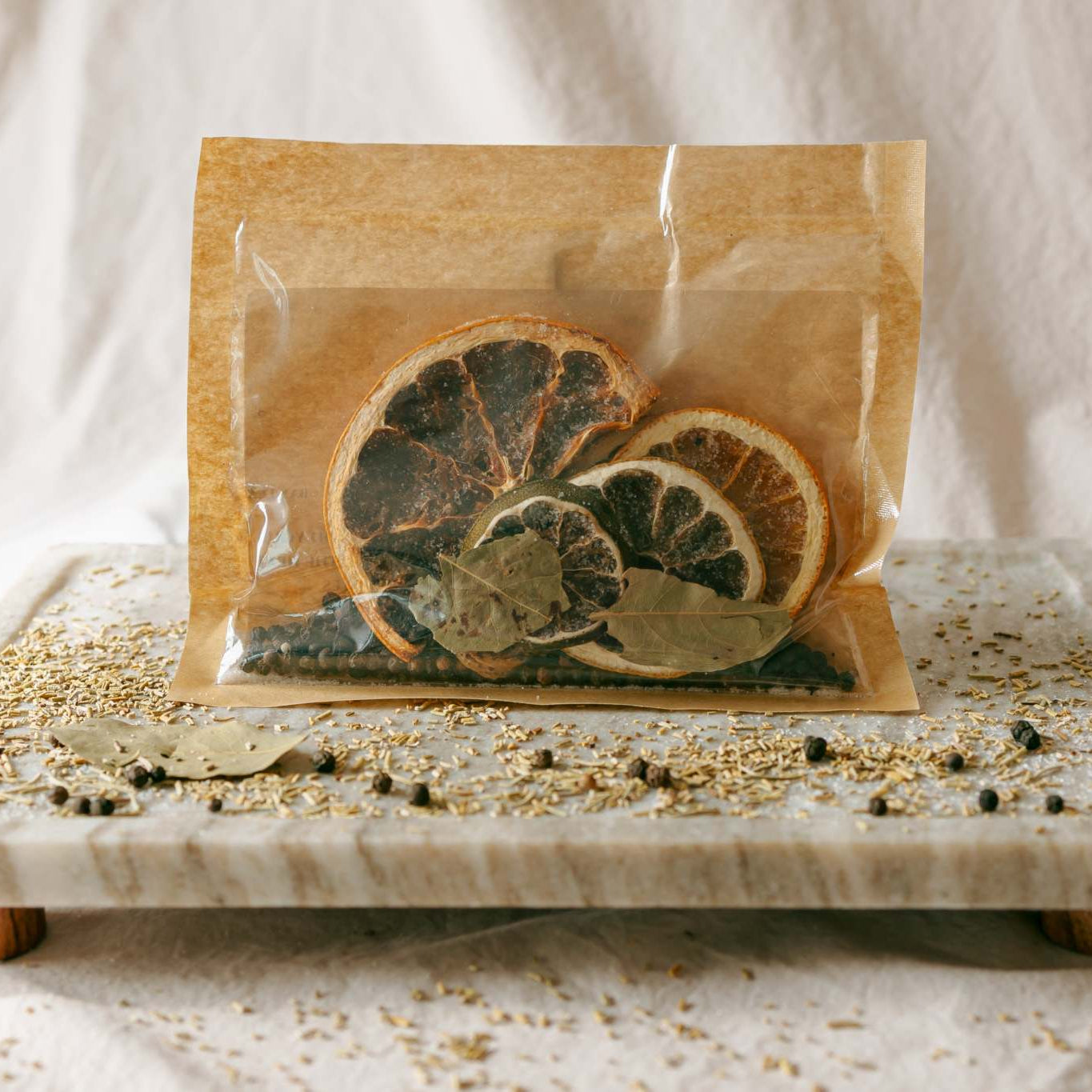 Packaged dried citrus slices on a marble tray with a neutral background