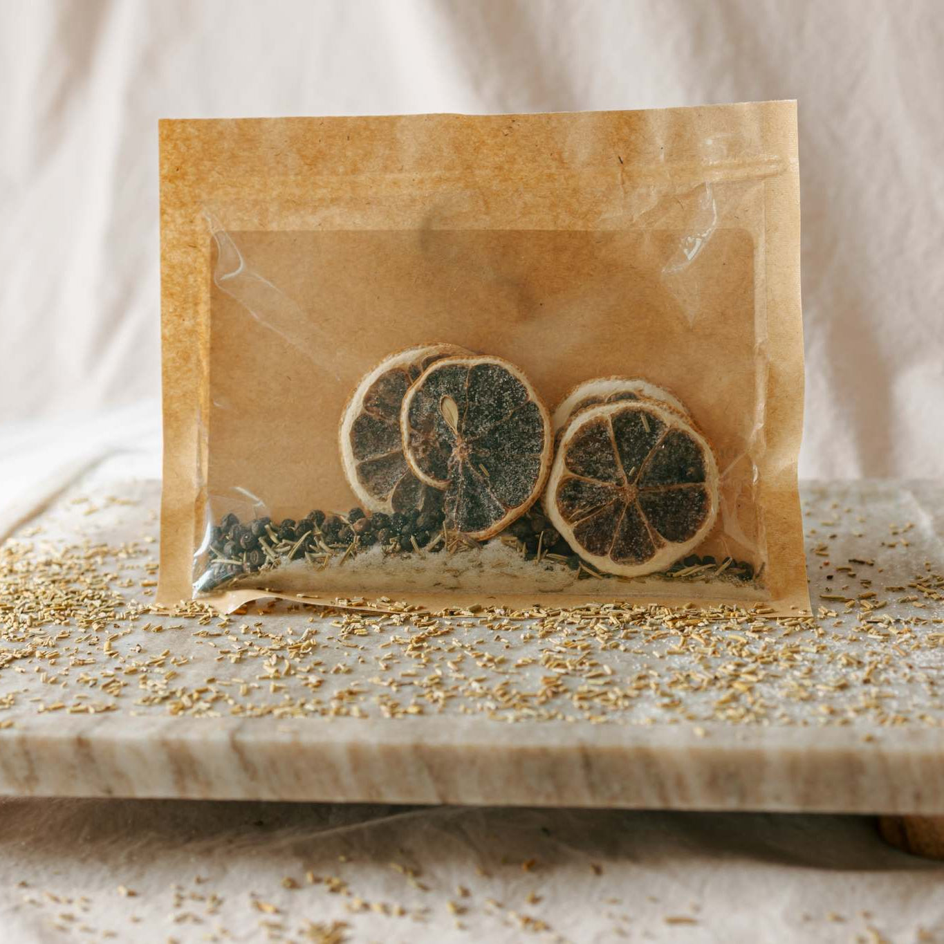 Tea bags with dried herbs on a marble tray with a white background
