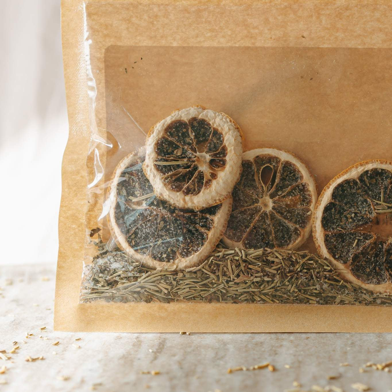 Dried lemon slices in a brown paper bag on a light background