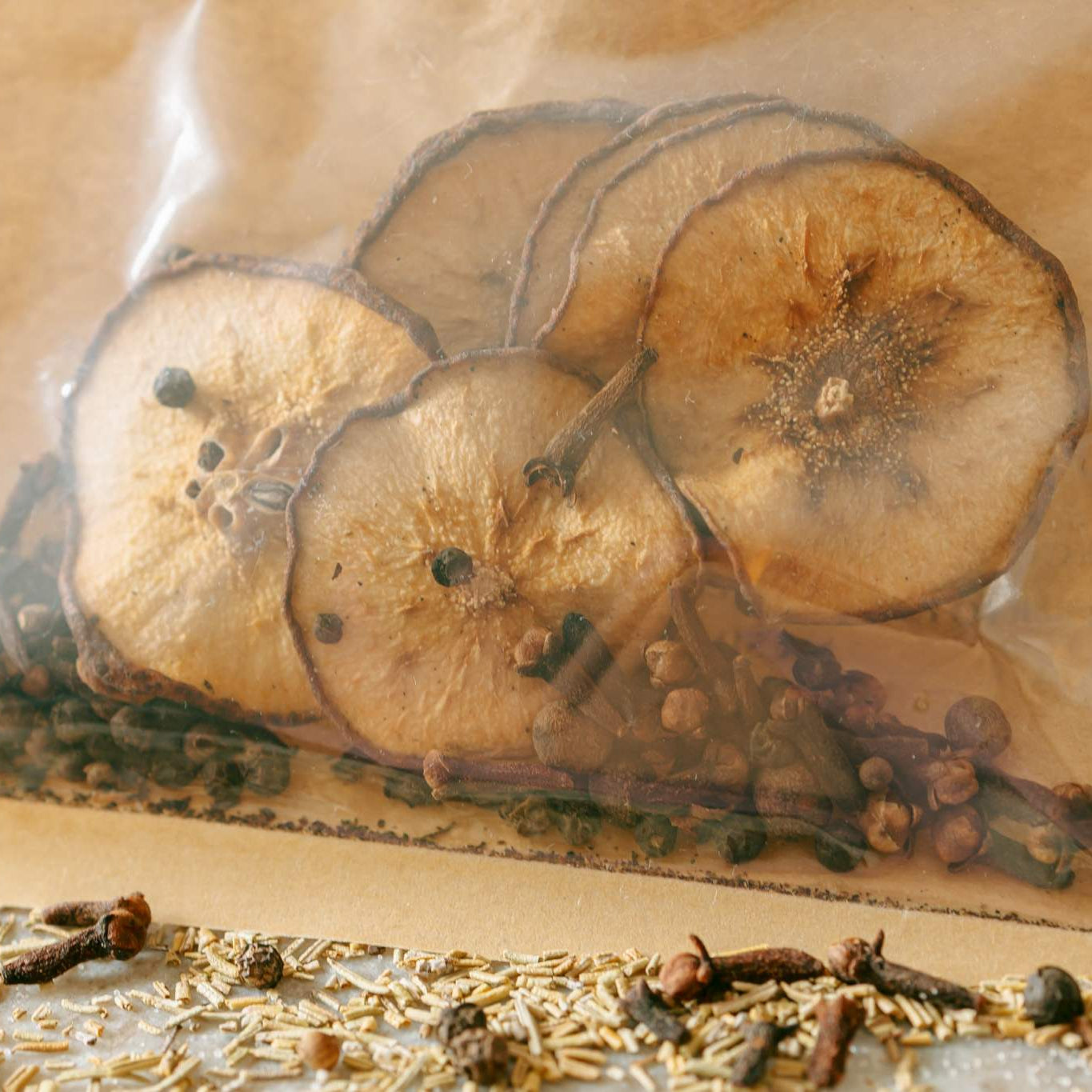 Dried fruits and spices in a clear plastic bag with a brown background
